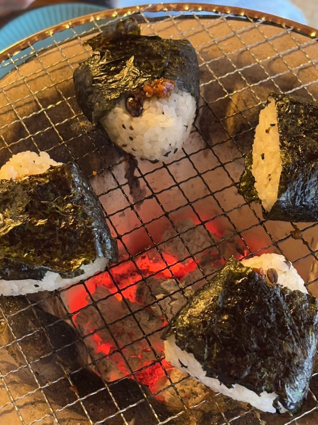七輪の中の炭は三ケ炭（みかんの木で作った炭）。ココリンにて焼きおにぎりを焼く。