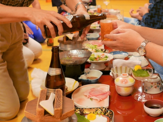 忘年会で、ビールをお酌する様子。