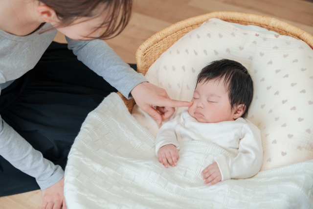 赤ちゃんのほっぺを触る母親