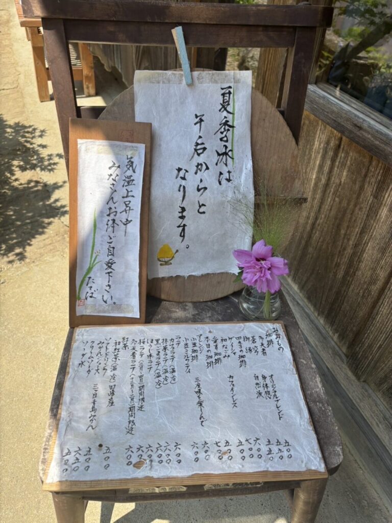夏季かき氷の案内板とメニュー表が置かれ、古びた木製のイス