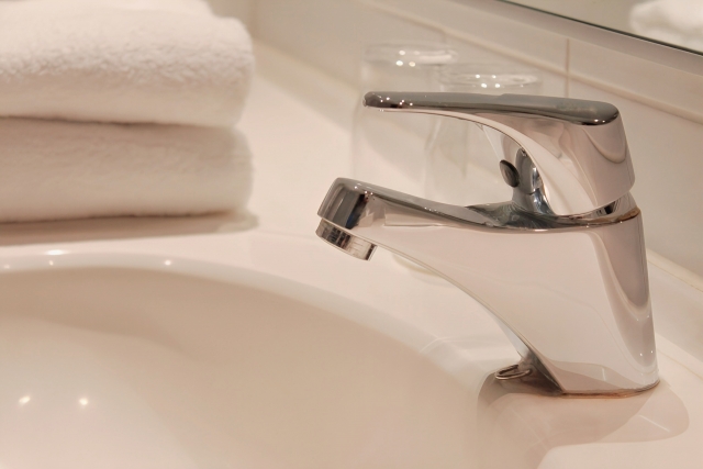 朝の洗面所の蛇口と白いタオル