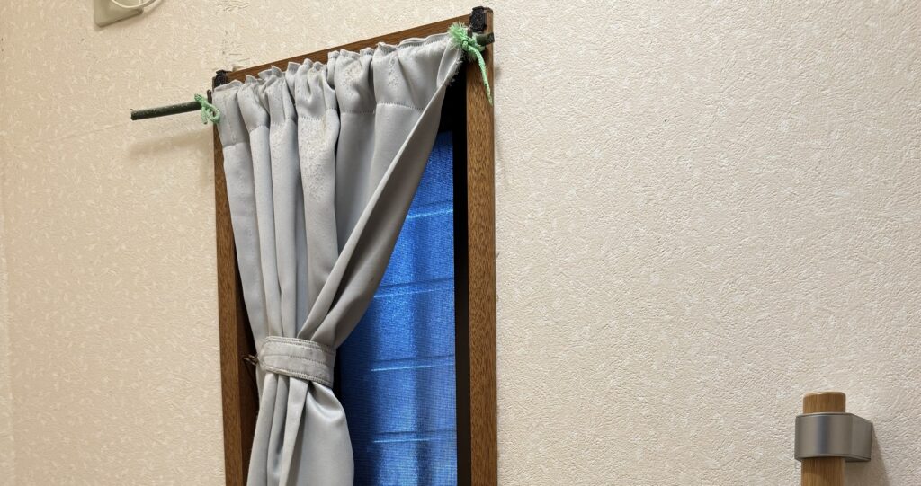 ガーデニング用の折れた支柱とビニールひもで取り付けたカーテン
