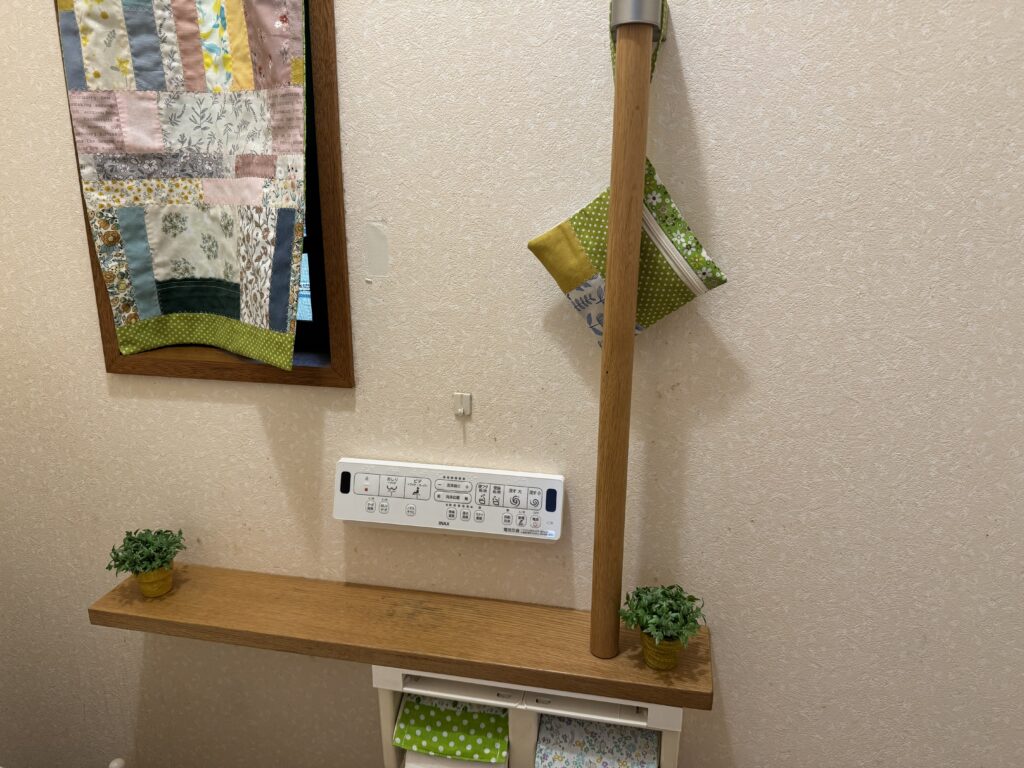手作りの布小物を取り付けた明るい雰囲気のトイレ